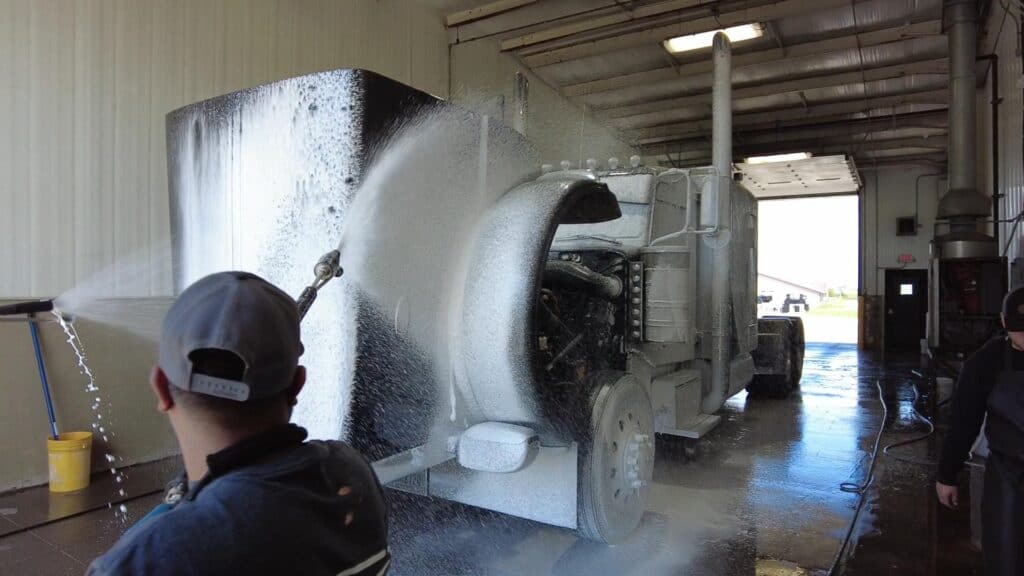 photo of workers soaping a semi during a truck wash