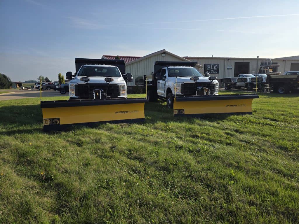 White Ford trucks with Meyer Lot Pro snow plows installed by truck bed installers in Ohio, serving customers nationwide.