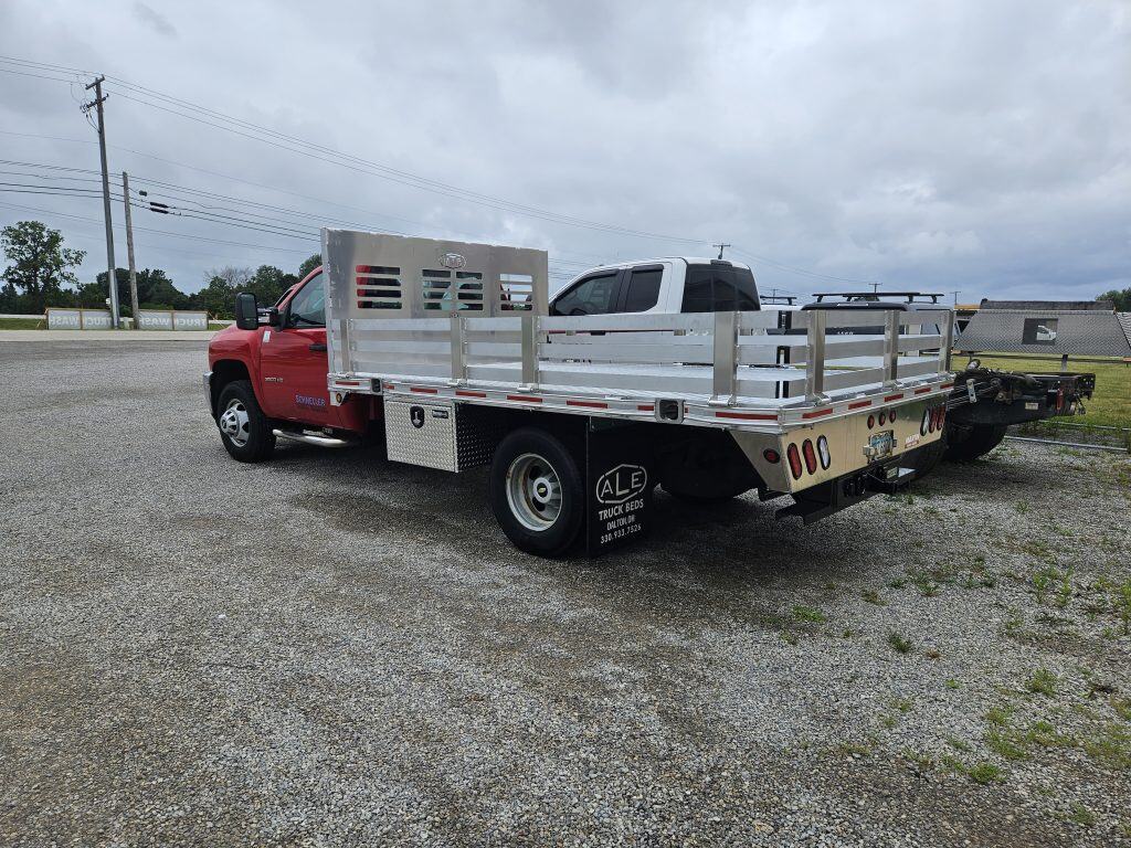 Red work truck with an aluminum platform stake body installed by ALE Truck Beds in Dalton, Ohio, designed for hauling landscaping and construction materials