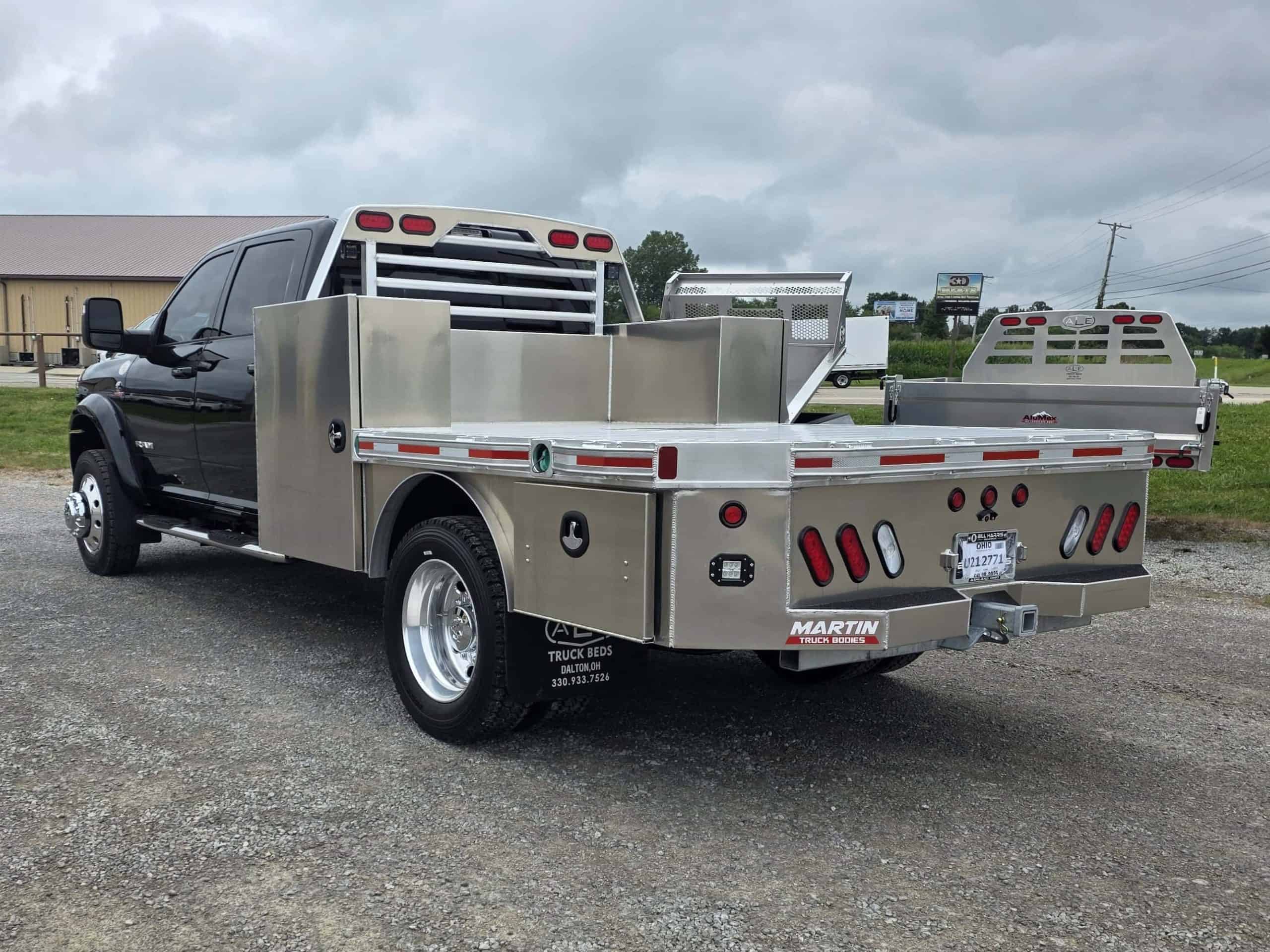 Black work truck with newly installed aluminum flatbed by ALE Truck Beds parked outdoors